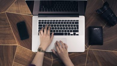 A person typing for blogging on a laptop on a desk